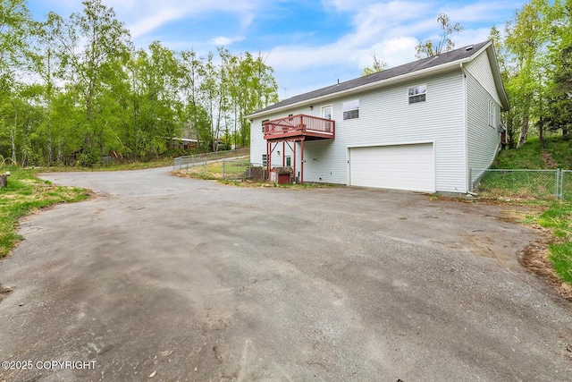 1151 W Gail Dr, Wasilla, AK 99654 - view of front facade with asphalt driveway, a garage, and a wooden deck