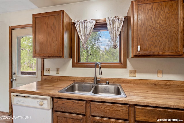 1031 E Dunedin St, Wasilla, AK 99654 - kitchen with white dishwasher, a sink, brown cabinetry, and butcher block countertops