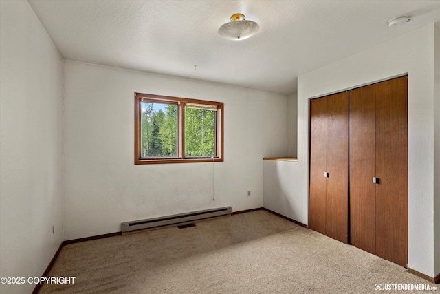 1031 E Dunedin St, Wasilla, AK 99654 - unfurnished bedroom featuring a baseboard heating unit, carpet, a closet, and baseboards