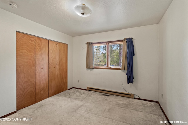 1031 E Dunedin St, Wasilla, AK 99654 - unfurnished bedroom featuring a baseboard radiator, baseboards, carpet flooring, and a closet