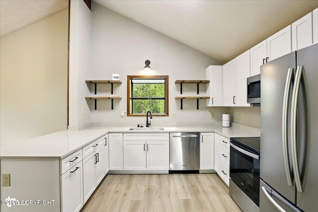 2921 Rocky Bay Cir, Anchorage, AK 99515 - kitchen featuring appliances with stainless steel finishes, open shelves, a sink, light wood-type flooring, and vaulted ceiling