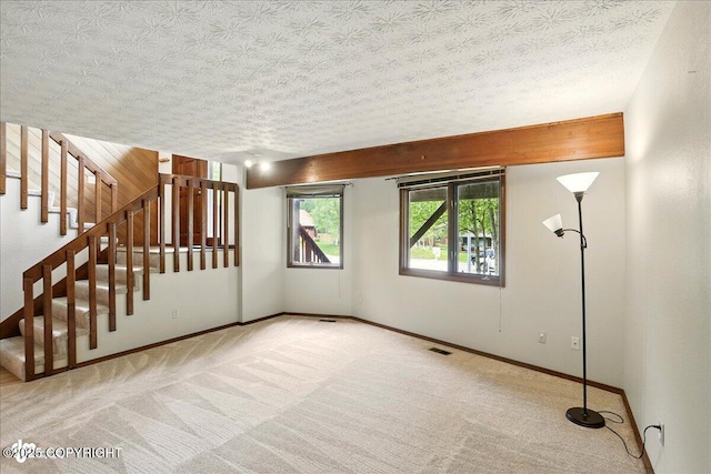2921 Rocky Bay Cir, Anchorage, AK 99515 - spare room with carpet, a textured ceiling, baseboards, and stairway