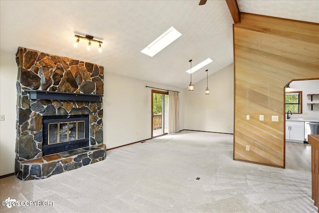 2921 Rocky Bay Cir, Anchorage, AK 99515 - unfurnished living room featuring a skylight, carpet flooring, a fireplace, a sink, and wooden walls