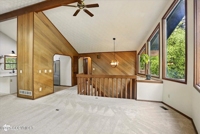 2921 Rocky Bay Cir, Anchorage, AK 99515 - carpeted empty room with lofted ceiling, wood walls, ceiling fan, a sink, and a chandelier