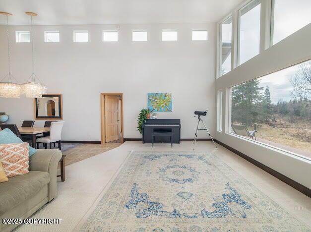 37397 Cetacea Ln, Kenai, AK 99611 - living area with a towering ceiling, plenty of natural light, carpet floors, and baseboards