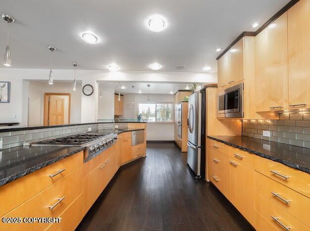 37397 Cetacea Ln, Kenai, AK 99611 - kitchen with appliances with stainless steel finishes, dark wood-style flooring, backsplash, and dark stone countertops