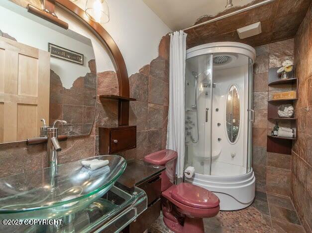 37397 Cetacea Ln, Kenai, AK 99611 - full bathroom with tile walls, shower / tub combo, toilet, and vanity