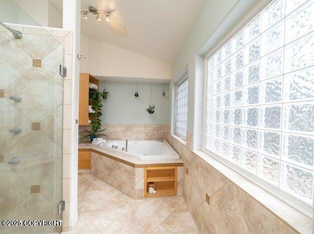 37397 Cetacea Ln, Kenai, AK 99611 - full bath featuring a shower stall, vaulted ceiling, a bath, a ceiling fan, and tile patterned floors