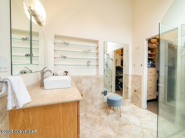37397 Cetacea Ln, Kenai, AK 99611 - full bath with a walk in closet, tile walls, tile patterned flooring, vanity, and a wainscoted wall