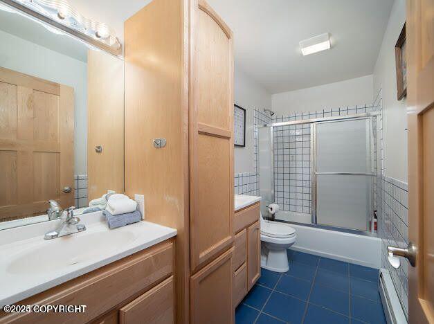 37397 Cetacea Ln, Kenai, AK 99611 - full bathroom featuring tile patterned floors, toilet, baseboard heating, and vanity