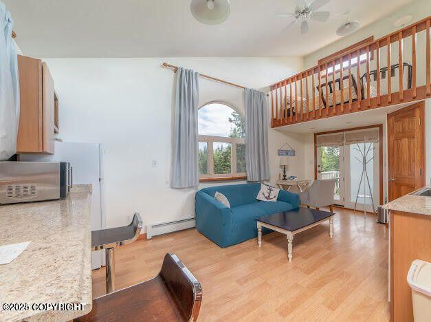 37397 Cetacea Ln, Kenai, AK 99611 - living room with a baseboard heating unit, healthy amount of natural light, and light wood-type flooring