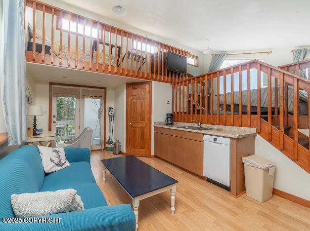 37397 Cetacea Ln, Kenai, AK 99611 - living room featuring light wood-style flooring, stairs, vaulted ceiling, and baseboards