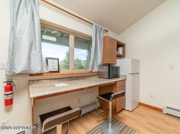 37397 Cetacea Ln, Kenai, AK 99611 - kitchen with black microwave, freestanding refrigerator, light wood-type flooring, a baseboard heating unit, and light countertops