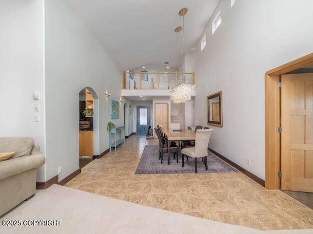 37397 Cetacea Ln, Kenai, AK 99611 - dining room featuring high vaulted ceiling, arched walkways, and baseboards