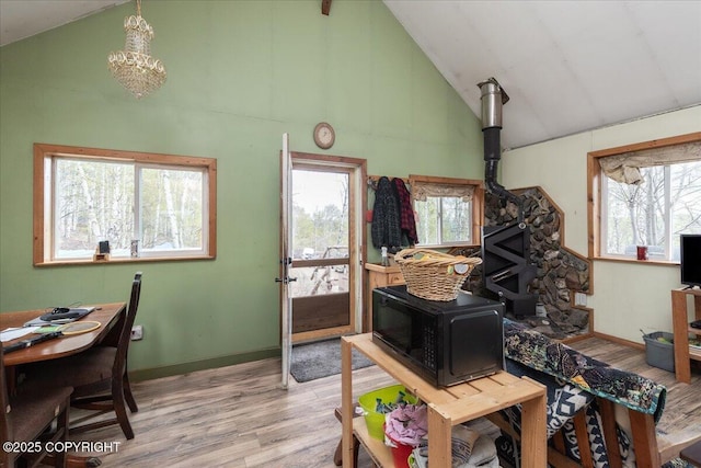 1080 Leuthold Dr, Fairbanks, AK 99712 - office area with a wood stove, wood finished floors, high vaulted ceiling, a chandelier, and baseboards