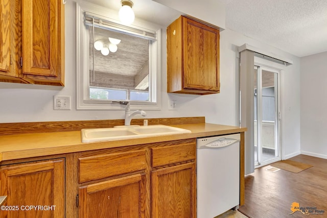 329 Gaylene Cir, Anchorage, AK 99504 - kitchen with white dishwasher, a sink, brown cabinetry, wood finished floors, and a textured ceiling