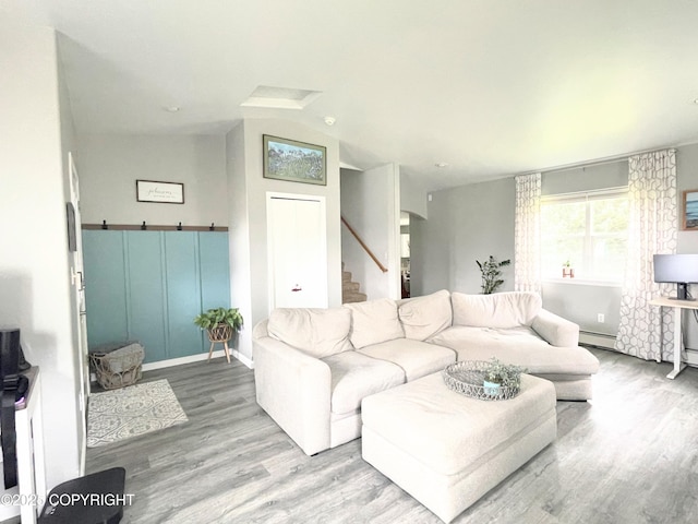 517 Sut Larsen Way, Kodiak, AK 99615 - living room featuring wood finished floors, stairway, vaulted ceiling, a baseboard heating unit, and arched walkways