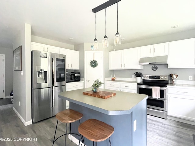 517 Sut Larsen Way, Kodiak, AK 99615 - kitchen featuring stainless steel appliances, under cabinet range hood, wood finished floors, a center island, and white cabinets