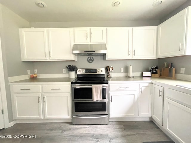 517 Sut Larsen Way, Kodiak, AK 99615 - kitchen with under cabinet range hood, double oven range, white cabinets, and light wood finished floors