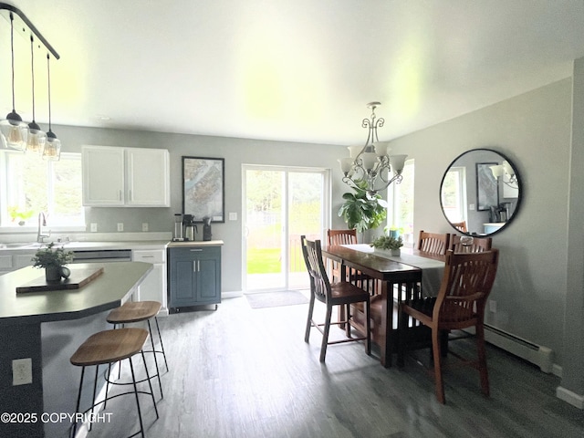 517 Sut Larsen Way, Kodiak, AK 99615 - dining space featuring a chandelier, wood finished floors, a baseboard radiator, and baseboards
