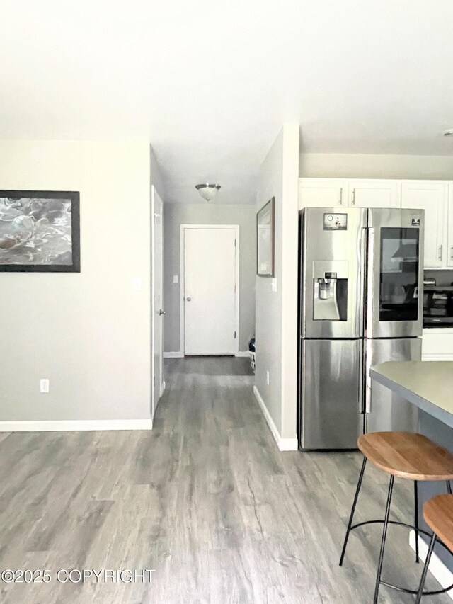 517 Sut Larsen Way, Kodiak, AK 99615 - kitchen featuring stainless steel fridge, white cabinetry, baseboards, light wood-style floors, and black microwave