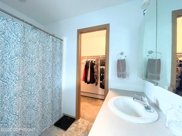 517 Sut Larsen Way, Kodiak, AK 99615 - bathroom featuring a baseboard radiator, a sink, a walk in closet, and a shower with shower curtain