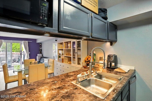 kitchen with a sink, black microwave, and dark countertops