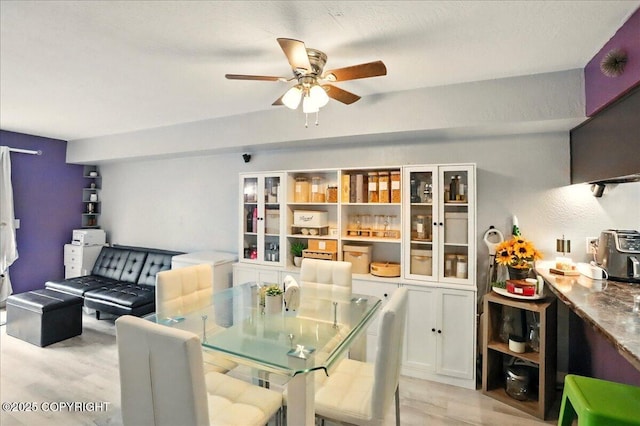 dining space with ceiling fan and light wood-type flooring