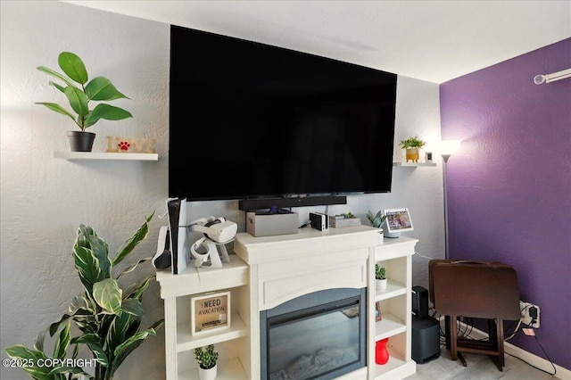 living area featuring baseboards and a textured wall