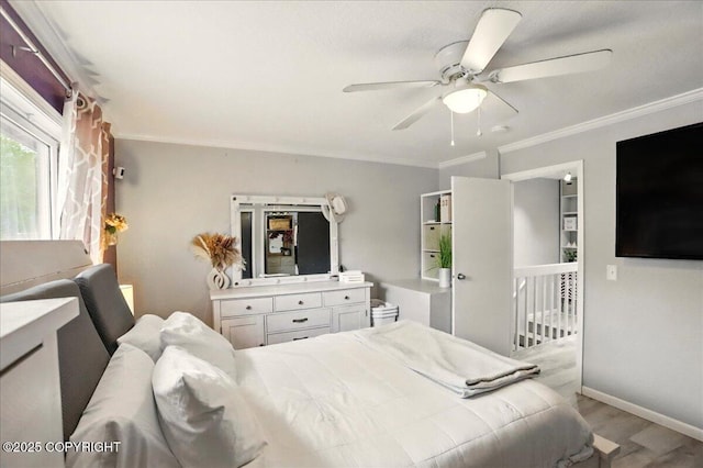 bedroom featuring wood finished floors, ornamental molding, baseboards, and a ceiling fan