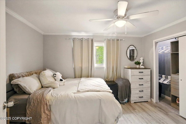 bedroom featuring light wood-type flooring, ornamental molding, and a ceiling fan