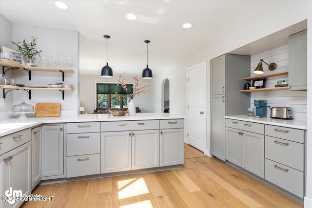 174 E Leota St, Wasilla, AK 99654 - kitchen with open shelves, gray cabinetry, a peninsula, light countertops, and arched walkways