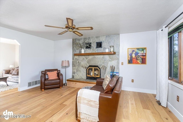 174 E Leota St, Wasilla, AK 99654 - living area with light wood finished floors, ceiling fan, arched walkways, baseboards, and a textured ceiling