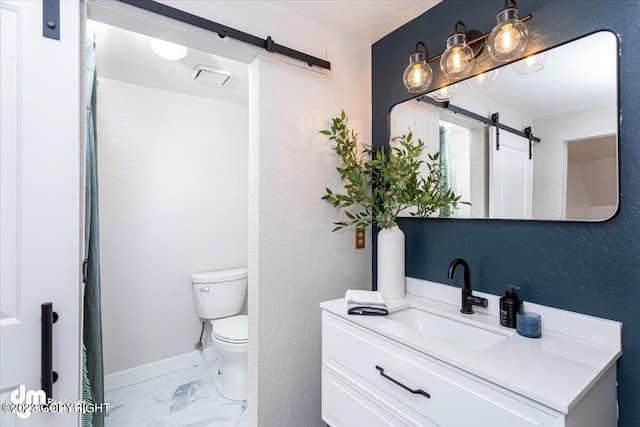 174 E Leota St, Wasilla, AK 99654 - bathroom with marble finish floors, toilet, vanity, and baseboards