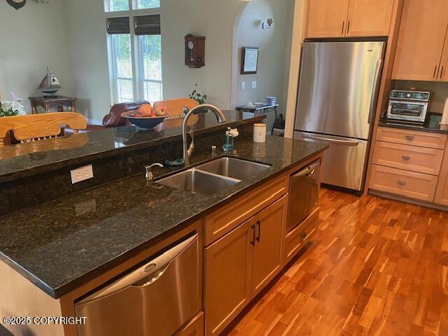 2295 N Filly Cir, Wasilla, AK 99654 - kitchen with appliances with stainless steel finishes, a sink, wood finished floors, and dark stone countertops