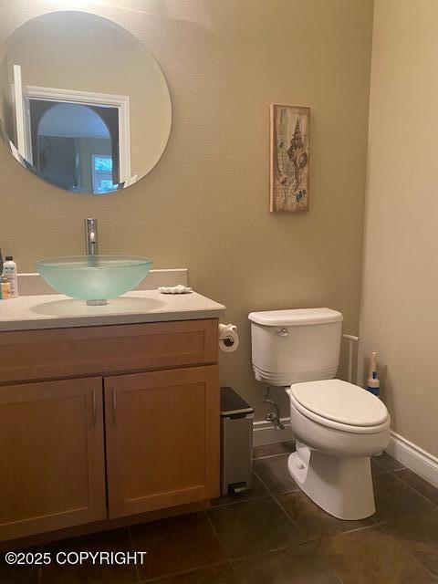 2295 N Filly Cir, Wasilla, AK 99654 - half bath featuring tile patterned floors, toilet, vanity, and baseboards
