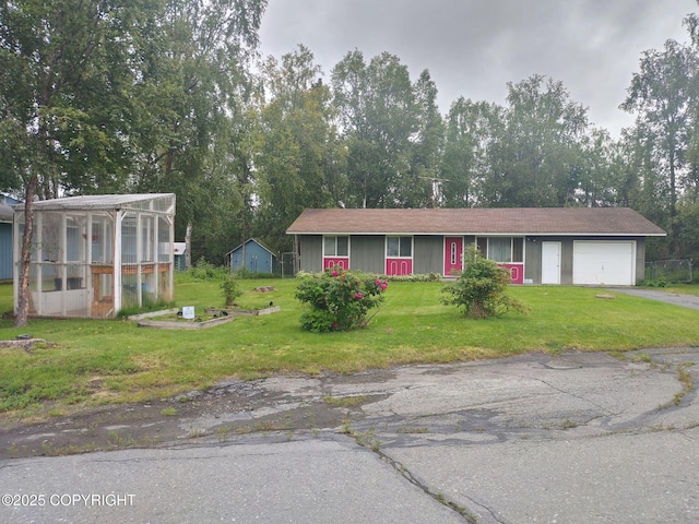 412 Pine Cir, Kenai, AK 99611 - view of front facade with asphalt driveway, a garage, a front yard, and a greenhouse