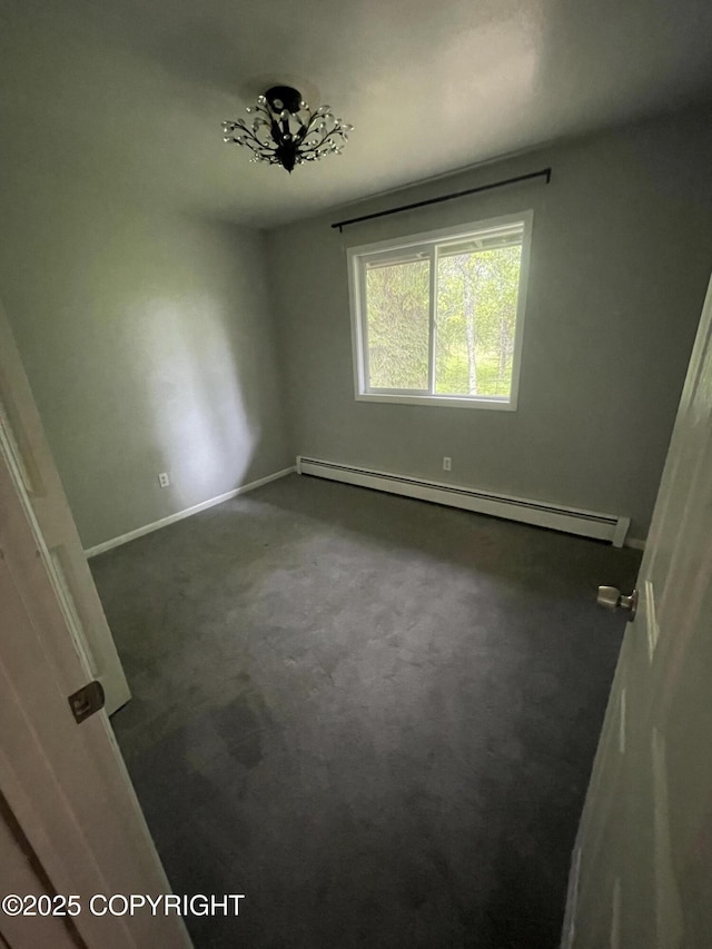 412 Pine Cir, Kenai, AK 99611 - empty room with a baseboard radiator, dark colored carpet, and baseboards