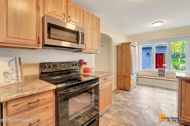 4147 Hampton Dr # 10D, Anchorage, AK 99504 - kitchen with stainless steel microwave, black range with electric cooktop, light brown cabinets, and arched walkways