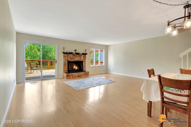 4147 Hampton Dr # 10D, Anchorage, AK 99504 - living area featuring light wood-style floors, plenty of natural light, a stone fireplace, and baseboards