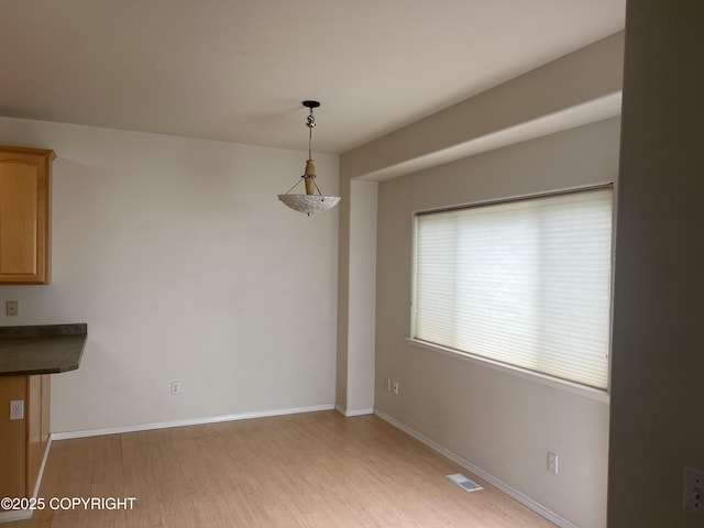 4766 Grumman St Unit 4766, Anchorage, AK 99507 - unfurnished dining area with light wood-type flooring and baseboards