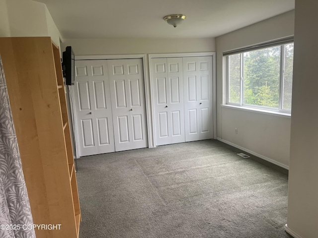 4766 Grumman St Unit 4766, Anchorage, AK 99507 - unfurnished bedroom with multiple closets, carpet flooring, and baseboards