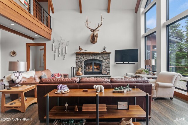 52619 Chumelina Ct, Kasilof, AK 99610 - living room featuring beam ceiling, healthy amount of natural light, wood finished floors, a towering ceiling, and a fireplace