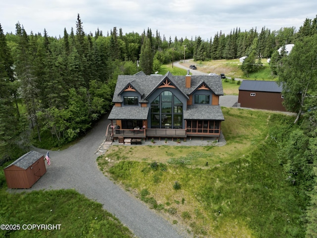 52619 Chumelina Ct, Kasilof, AK 99610 - view of front facade with gravel driveway, a chimney, a forest view, roof with shingles, and a deck