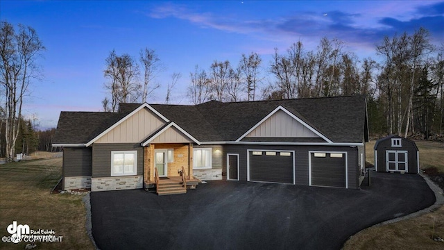 1630 S Corwin Ln, Wasilla, AK 99654 - view of front of house with an attached garage, board and batten siding, asphalt driveway, roof with shingles, and stone siding
