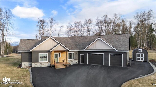 1630 S Corwin Ln, Wasilla, AK 99654 - view of front of house featuring an attached garage, board and batten siding, driveway, stone siding, and a shingled roof