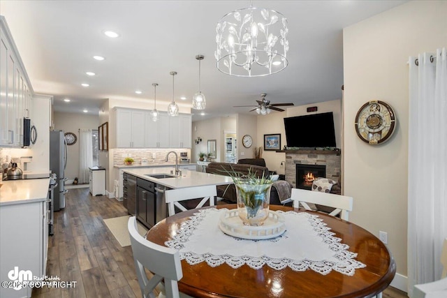 1630 S Corwin Ln, Wasilla, AK 99654 - dining space with recessed lighting, a ceiling fan, a fireplace, dark wood-style flooring, and a chandelier