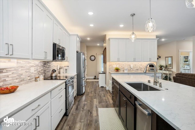 1630 S Corwin Ln, Wasilla, AK 99654 - kitchen featuring a sink, appliances with stainless steel finishes, tasteful backsplash, hanging light fixtures, and white cabinets