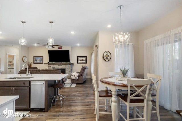 1630 S Corwin Ln, Wasilla, AK 99654 - dining space with a ceiling fan, a fireplace, wood finished floors, a chandelier, and recessed lighting
