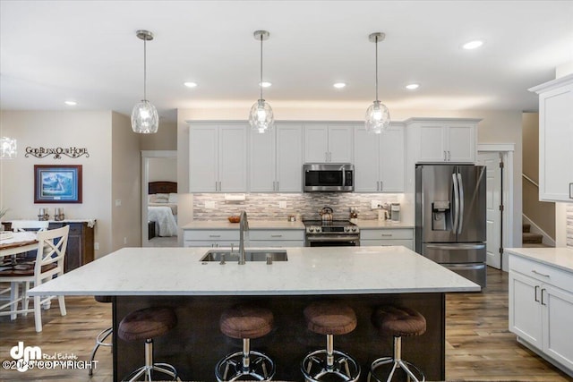 1630 S Corwin Ln, Wasilla, AK 99654 - kitchen featuring stainless steel appliances, a sink, a kitchen bar, tasteful backsplash, and recessed lighting